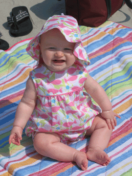 On the blanket in her beach hat