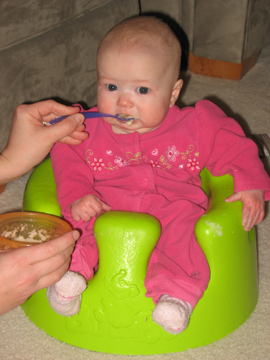 Eating her first cereal meal